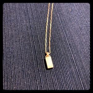 Silver necklace with white opalescent pendant.